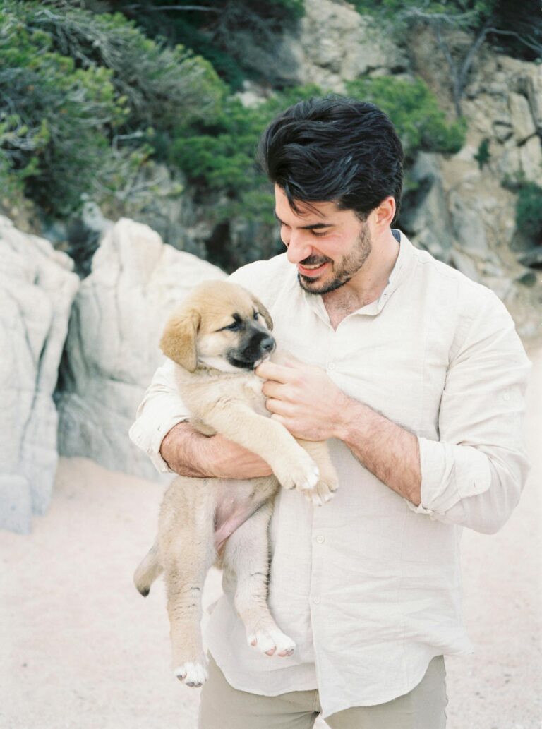 Smiling Man Carrying a Puppy